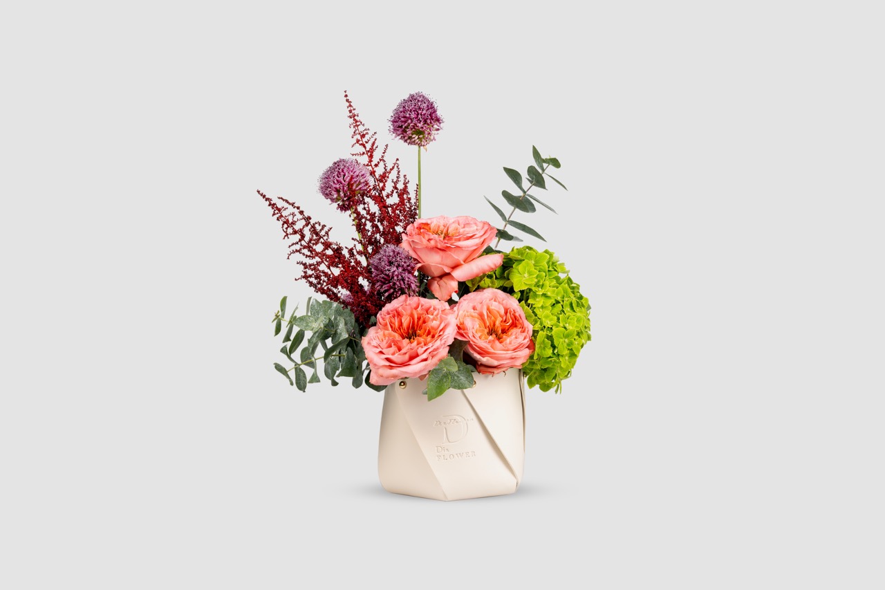 Flowers arranged in a designer leather bag