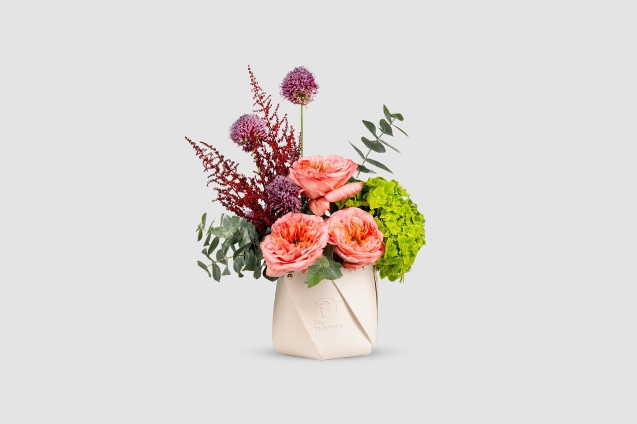 Fresh flowers arranged in a designer leather bag